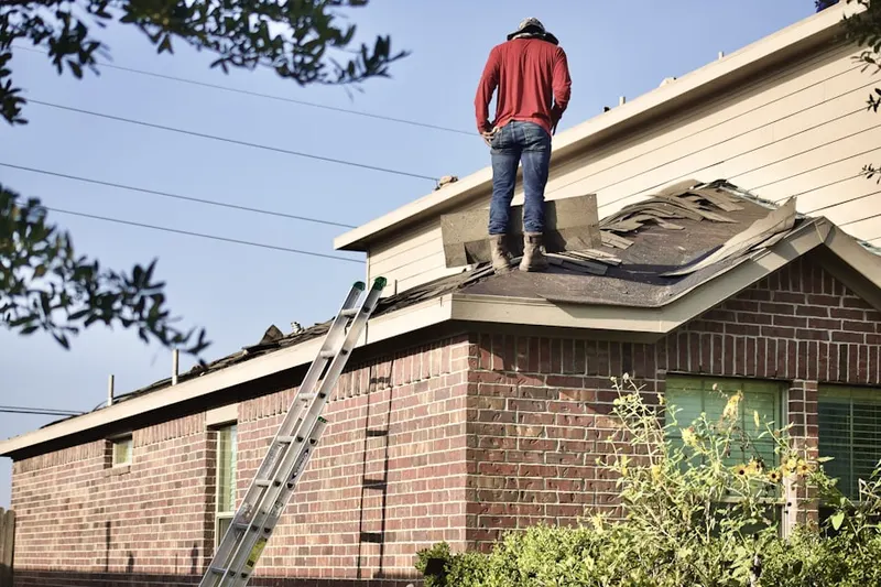 Professional roofer working on a residential roof in Islandia